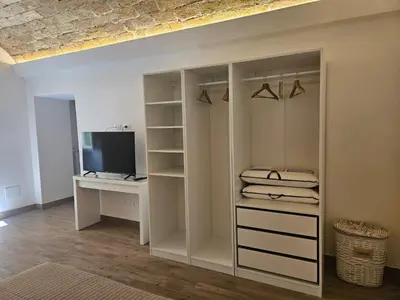 a white closet with a desk and a television at Campani Luxury Suite in Rome