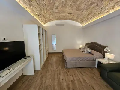 a bedroom with a bed and a tv and a couch at Campani Luxury Suite in Rome