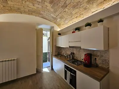 a kitchen with white cabinets and a brick ceiling at Campani Luxury Suite in Rome