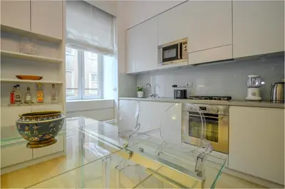 a large white kitchen with a glass table in it at Gracchi Apartment Prati in Rome