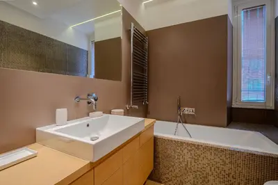 a bathroom with a white sink and a tub at Gracchi Apartment Prati in Rome