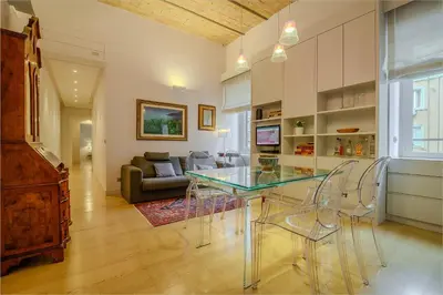 a kitchen and living room with a glass table and chairs at Gracchi Apartment Prati in Rome