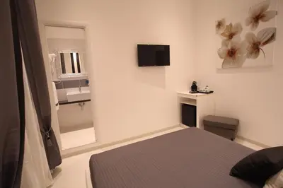 a small bedroom with a bed and a mirror at Guesthouse Interno 7 Luxury Rooms in Rome