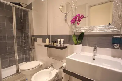a white bathroom with a sink and a toilet at Guesthouse Interno 7 Luxury Rooms in Rome