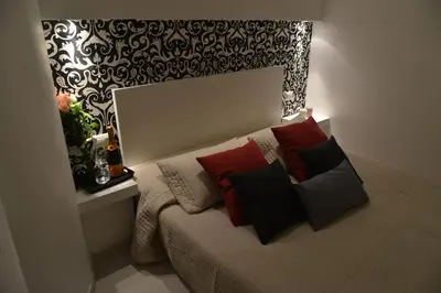 a bedroom with a bed with red and black pillows at Guesthouse Interno 7 Luxury Rooms in Rome