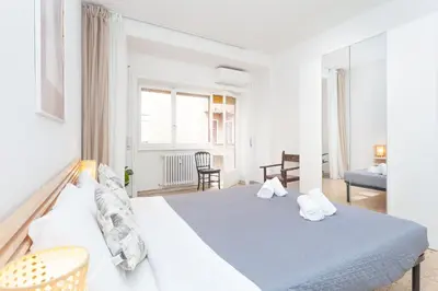 a white bedroom with a bed and a chair at via Madonna del Riposo in Rome