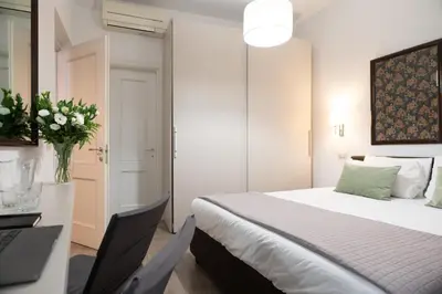 a bedroom with a bed and a desk with a vase of flowers at Banchi Vecchi Stay Apt Suite Navona in Rome