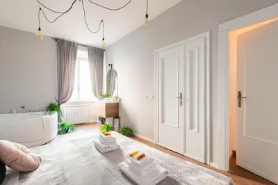 a bathroom with a white tub and a large window at Termini apartments in Rome