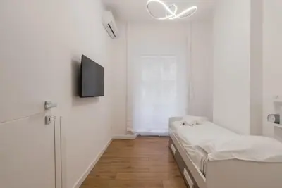 a white room with a bed and a flat screen tv at THE FIFTH Properties Luxury Apartment near LUISS Rome Viale Libia in Rome