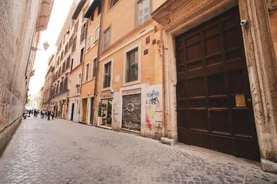 an empty street in an alley with buildings at Pettinari by BuddyRent in Rome