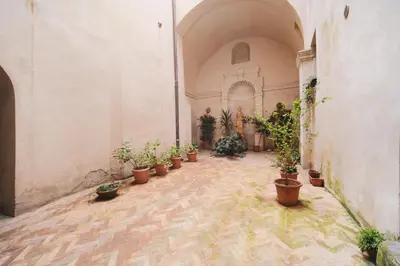 a hallway with potted plants in a building at Pettinari by BuddyRent in Rome