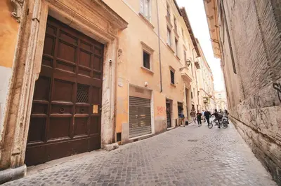 a group of people walking down a cobblestone alley at Pettinari by BuddyRent in Rome