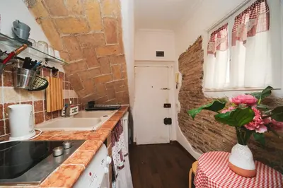 a kitchen with a vase of flowers on a table at Pettinari by BuddyRent in Rome