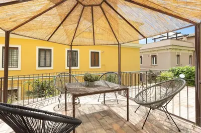 a patio with a table and chairs and an umbrella at Appartamento San Pietro-Vaticano in Rome