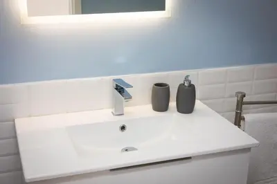 a white bathroom sink with two bottles on it at Appartamento San Pietro-Vaticano in Rome