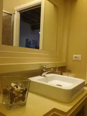 a white sink in a bathroom with a mirror at Orso Luxury Apartment in Rome