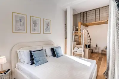 a bedroom with a white bed with blue pillows at Domus Sabina in Rome