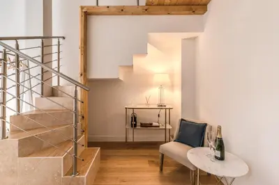 a living room with a staircase and a chair at Domus Sabina in Rome