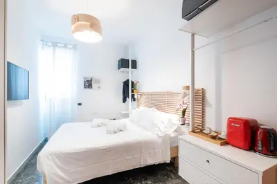 a bedroom with a white bed and a red suitcase at 4BNB - Reale House in Rome