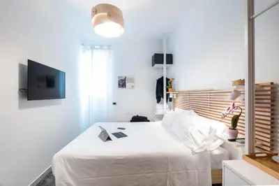 a white bedroom with a white bed and a tv at 4BNB - Reale House in Rome