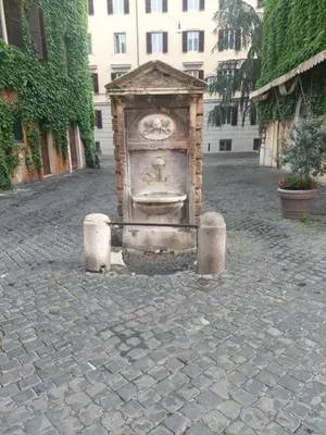 a stone fountain on a cobblestone street at Borgo Pio 182 Vatican Suite in Rome
