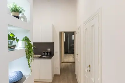 a kitchen with white cabinets and a hallway at Navona Modern by Rental in Rome in Rome