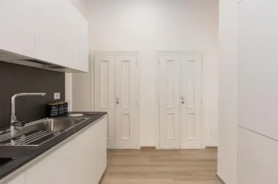 a kitchen with white cabinets and a sink at Navona Modern by Rental in Rome in Rome