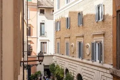 an alley between two buildings with people walking down the street at Navona Modern by Rental in Rome in Rome
