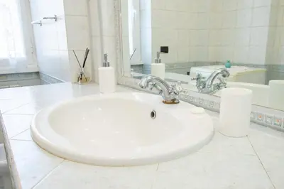 a bathroom with a white sink and a mirror at 81 mq, Stazione trastevere, Rome Sweet Home in Rome