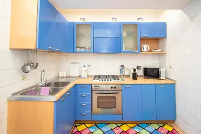 a small kitchen with blue cabinets and a sink at 81 mq, Stazione trastevere, Rome Sweet Home in Rome