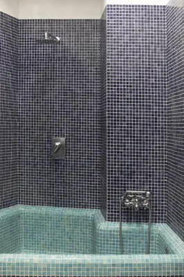 a blue tiled bathroom with a blue tub at Casa Albani in Rome