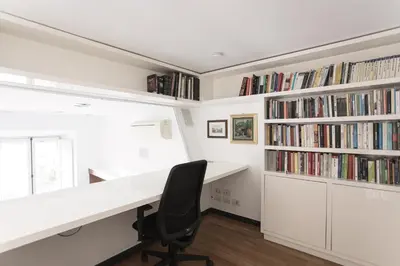 a home office with a white desk and bookshelves at Casa Albani in Rome
