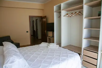a bedroom with a large white bed and open shelving at RomAmo Sogliano4 in Rome