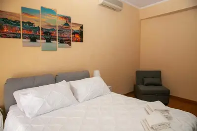 a bedroom with a white bed and a chair at RomAmo Sogliano4 in Rome