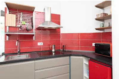 a kitchen with a sink and a red wall at Trastevere novecento in Rome