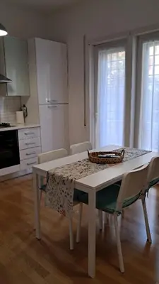 a white table and chairs in a kitchen with a table at Roberta Rome Vatican Flat in Rome