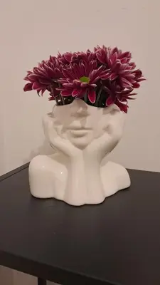 a white vase with purple flowers in it on a table at Roberta Rome Vatican Flat in Rome