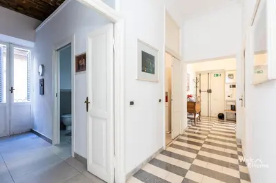 a hallway with a white door and a checkered floor at Maison Borghetto - Vatican House in Rome