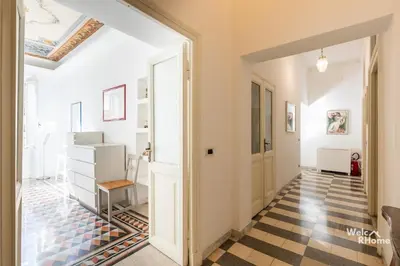 a hallway with a checkered floor and an open door at Maison Borghetto - Vatican House in Rome