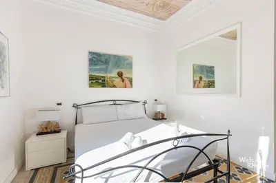 a bedroom with a bed and two pictures on the wall at Maison Borghetto - Vatican House in Rome