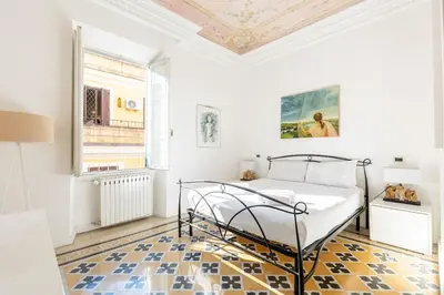 a white bedroom with a bed and a window at Maison Borghetto - Vatican House in Rome