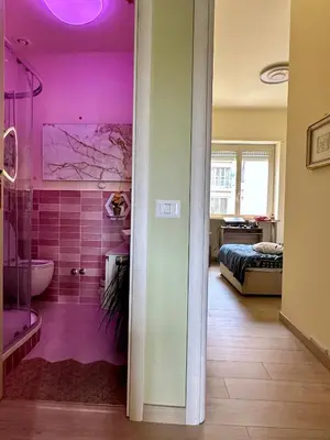 a bathroom with pink walls and a bathroom with a tub at Sanpaolo Modern Aesthetic B&B in Rome