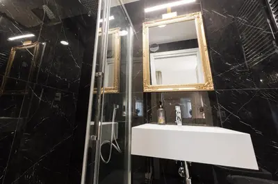 a bathroom with a sink and a mirror at De Vince Suites - Luxury Rooms - Roma Termini in Rome