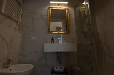 a bathroom with a sink and a shower and a mirror at De Vince Suites - Luxury Rooms - Roma Termini in Rome