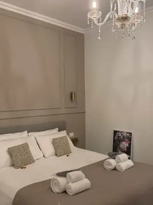 a bedroom with two beds with towels on them at De Vince Suites - Luxury Rooms - Roma Termini in Rome