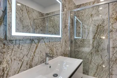 a bathroom with a sink and a glass shower at NAIF Suites in Rome
