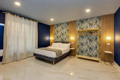 a bedroom with a bed and a blue wall at NAIF Suites in Rome