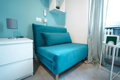 a blue couch in a room with a window at Salotto Tiburtino in Rome