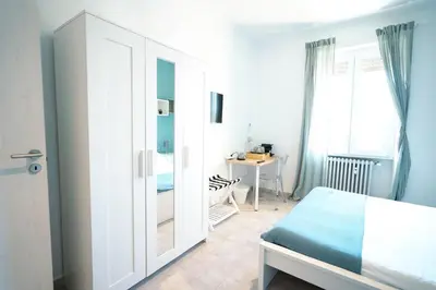 a bedroom with a bed and a desk and a mirror at Salotto Tiburtino in Rome