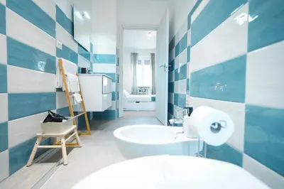 a bathroom with blue and white tiles on the wall at Salotto Tiburtino in Rome